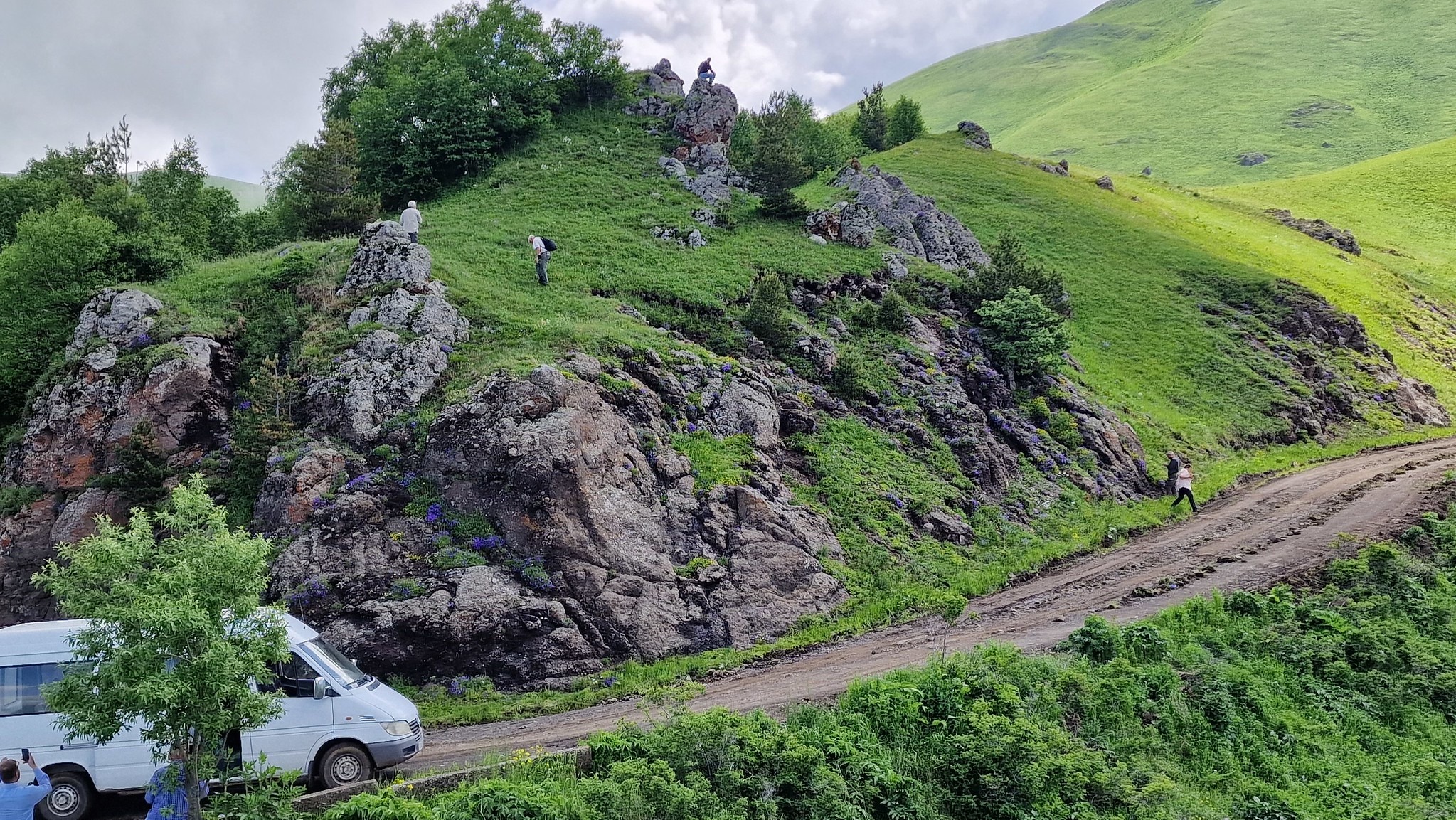 Gruppe von Botanikern erkundet blumenreiche Felsbiotope bei Bakuriani im Kleinen Kaukasus, Georgien – im Vordergrund der Reise-Kleinbus