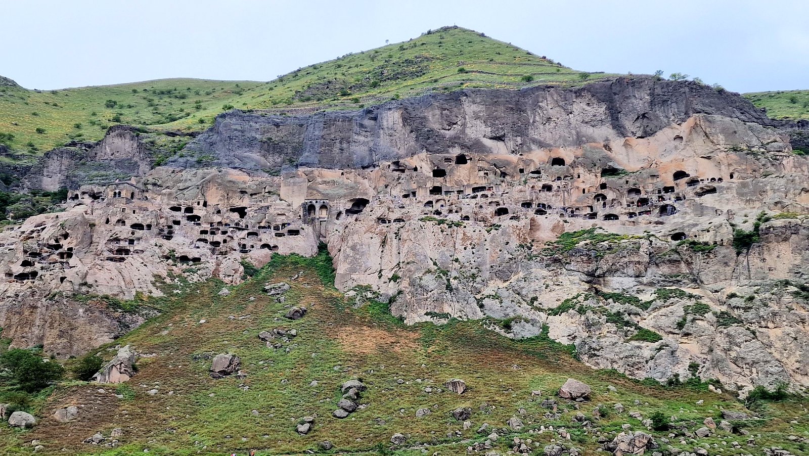 Blick auf die mittelalterliche Höhlenstadt Wardsia in Südgeorgien – hunderte in den Fels gehauene Kammern und Kirchen übereinander in einer steilen Felswand