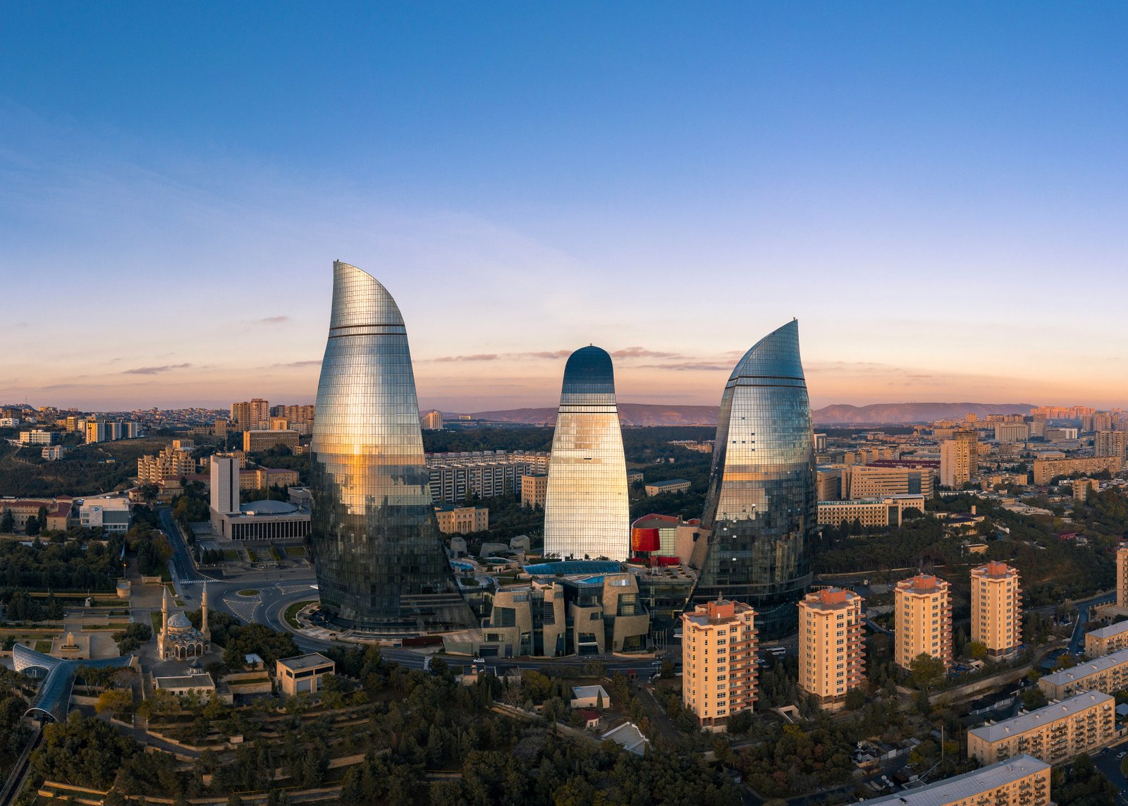 Mittelalterliche Altstadt Icheri Sheher in Baku mit den modernen Flammentürmern im Hintergrund und blauem Himmel
