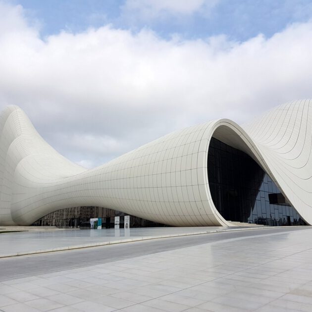 Das weiße geschwungene Heydar Aliyev Center in Baku, entworfen von Zaha Hadid, vor bewölktem Himmel