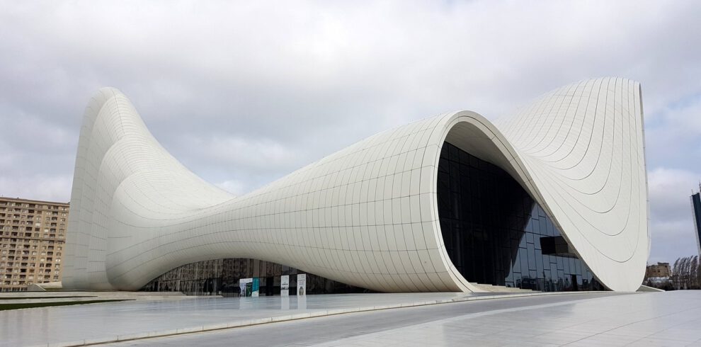 Das weiße geschwungene Heydar Aliyev Center in Baku, entworfen von Zaha Hadid, vor bewölktem Himmel