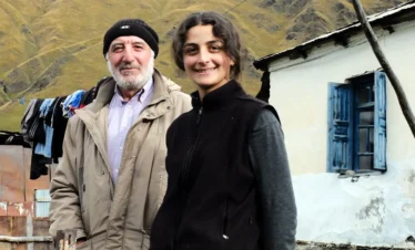 Porträt eines älteren georgischen Mannes und einer jungen Frau vor ihrem Haus im Bergdorf Ushguli, Swanetien.