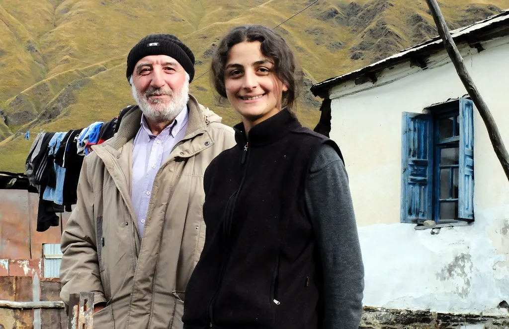 Porträt eines älteren georgischen Mannes und einer jungen Frau vor ihrem Haus im Bergdorf Ushguli, Swanetien.