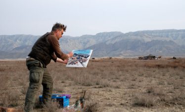 Künstler Heiner Buhr malt ein expressionistisches Bild en plein air in der Steppe des Nationalparks Vashlovani vor den Sandsteinfelsen