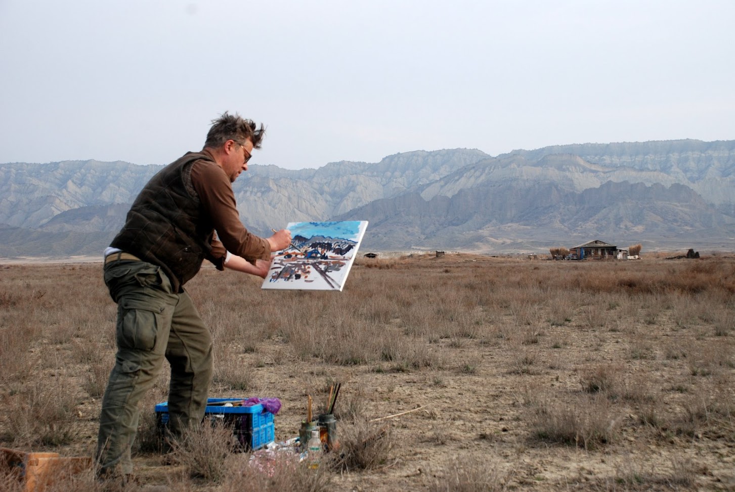 Künstler Heiner Buhr malt ein expressionistisches Bild en plein air in der Steppe des Nationalparks Vashlovani vor den Sandsteinfelsen