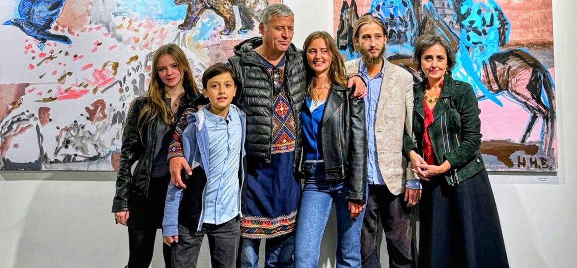 Hans Heiner Buhr und Teona Buhr mit ihren vier Kindern in Georgien vor Ölgemälden des Künstlers.