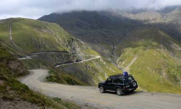 Ein professioneller Fahrer-Guide von Kaukasus-Reisen steuert einen Geländewagen sicher über die Serpentinen des Abano-Passes in Georgien.