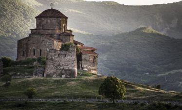Das frühmittelalterliche Kloster Dshwari bei Mzcheta Georgien auf einem Hügel im grünen Abendlicht mit Bergen im Nebel
