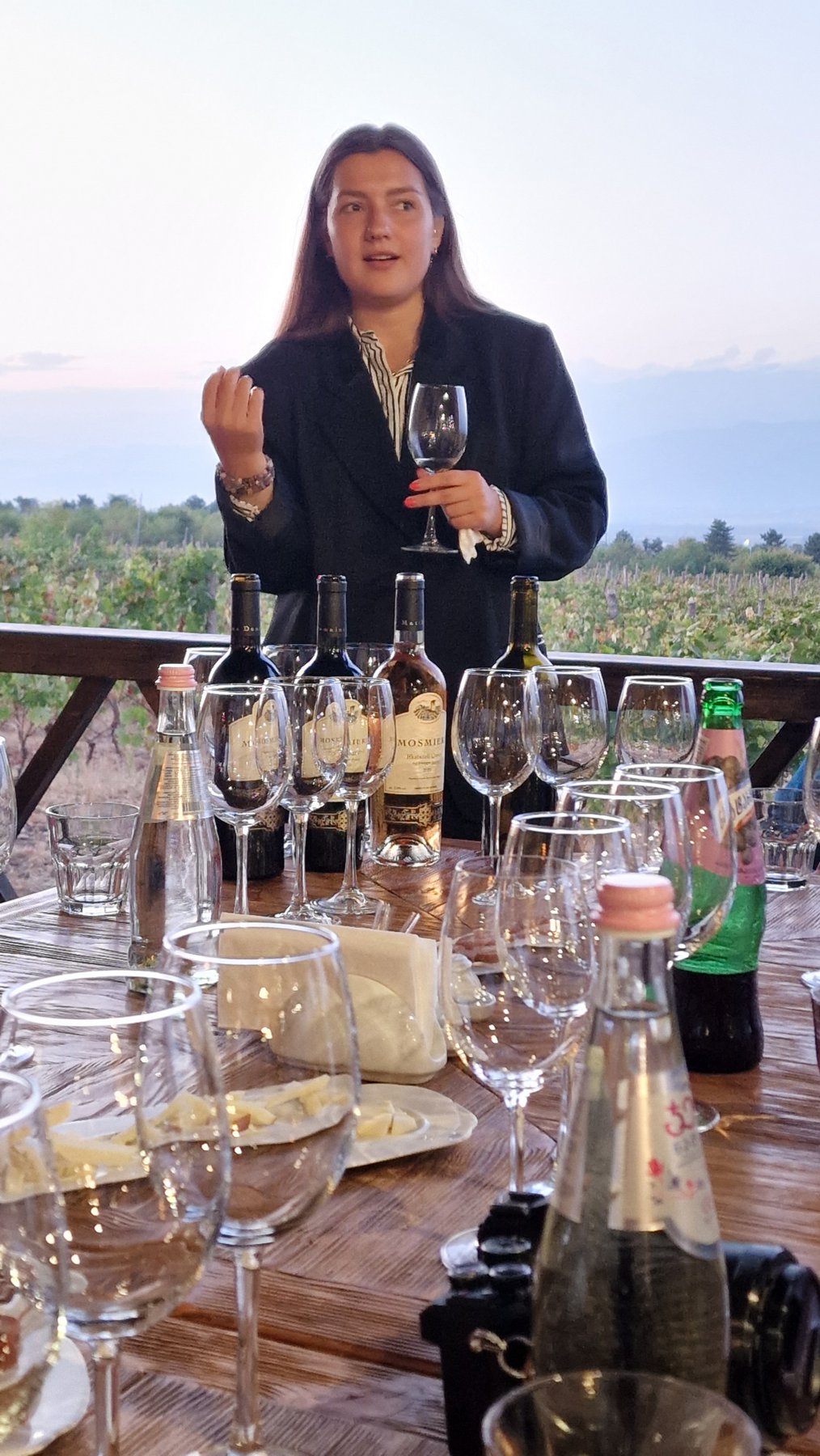 Junge Sommelière erklärt bei einer Weinverkostung auf einem Weingut in Kachetien Georgien verschiedene Weine im Weinberg