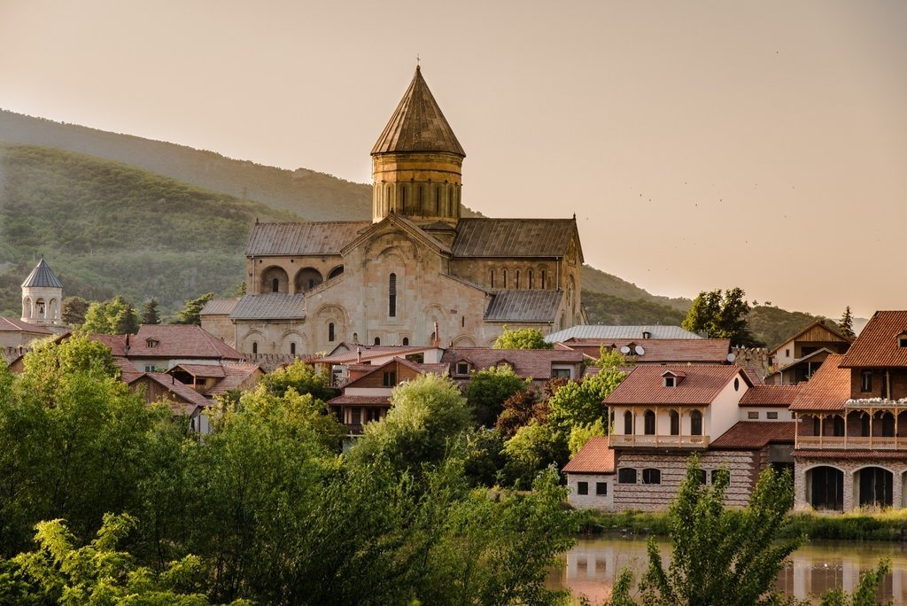 Die Swetizchoweli Kathedrale in Mzcheta Georgien im goldenen Abendlicht mit dem Fluss Mtkvari und grünen Bergen im Hintergrund