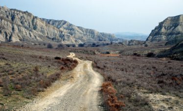 Unbefestigte Piste führt durch die surreale Mondlandschaft aus erodierten Sandsteinfelsen im Nationalpark Vashlovani, Georgien