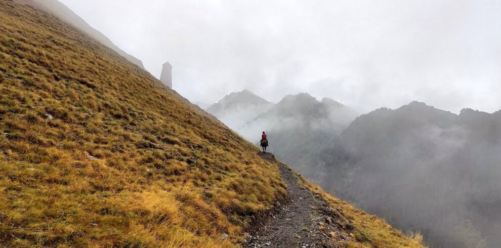 Reiterreise Tuschetien – Einsamer Reiter im Nebel mit Wehrturm Tuschetien Georgien