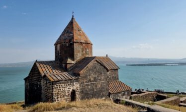 Das mittelalterliche Kloster Sevanavank aus dunklem Tuffstein auf einer Halbinsel über dem türkisfarbenen Sewansee in Armenien