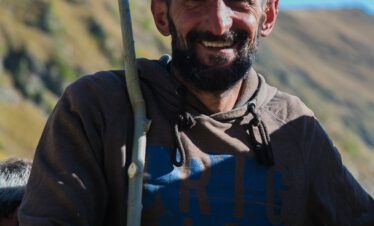 Lachender tuschetischer Schäfer mit Hirtenstab beim Viehtrieb Tuschetien Georgien