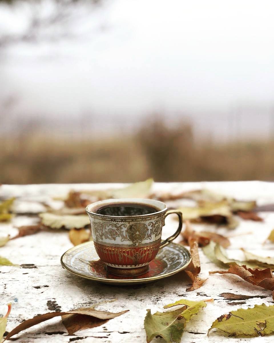 Antike armenische Kaffeetasse auf einem verwitterten Tisch mit Herbstblättern, Armenien