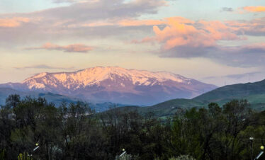 Snowy Armenian mountains at sunset with soft pink clouds