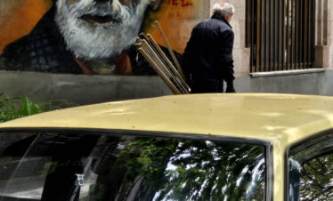 Street mural of Sayat-Nova beside an old car in Yerevan